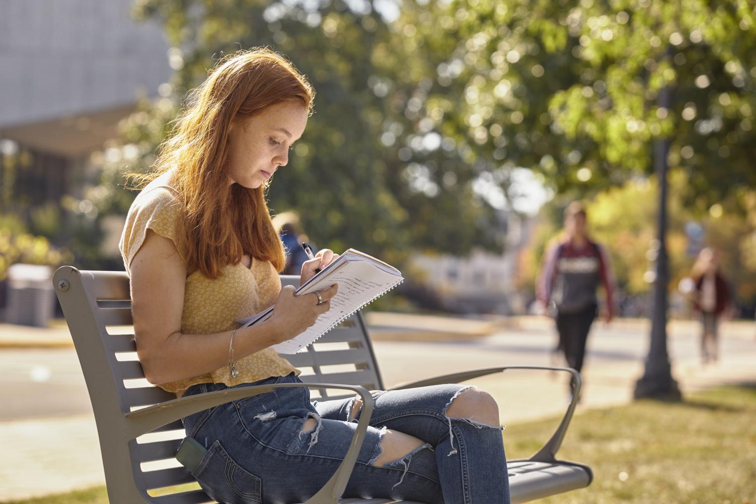 一位<a href='http://ojum.ngskmc-eis.net'>全球十大赌钱排行app</a>学院的学生在校园里的长椅上读书.